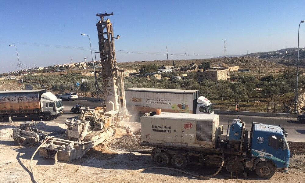 מכונית קידוחים בעבודה באמצע הכביש